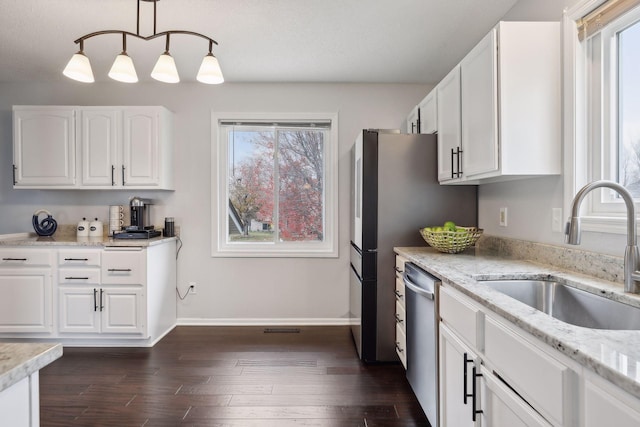 kitchen with sink, pendant lighting, dishwasher, white cabinets, and dark hardwood / wood-style floors