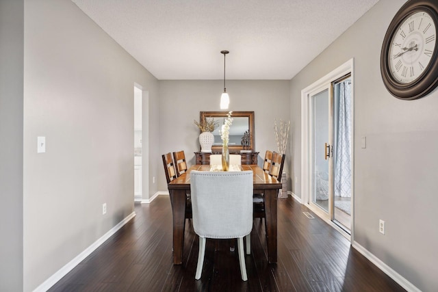 dining space featuring dark hardwood / wood-style floors and a textured ceiling