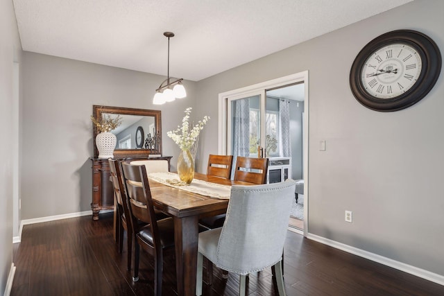 dining space featuring dark hardwood / wood-style flooring and a textured ceiling