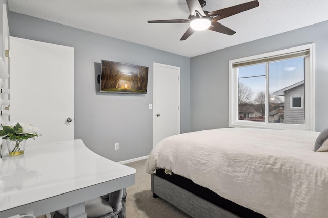 carpeted bedroom featuring ceiling fan and a textured ceiling