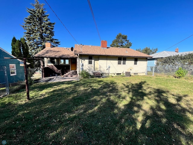 back of property with a yard and central air condition unit