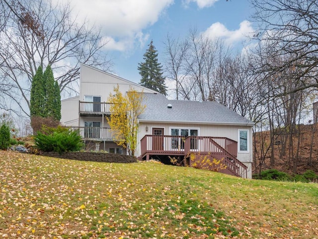 back of house with a deck and a lawn