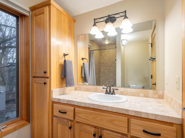 bathroom featuring a shower with curtain, vanity, and toilet