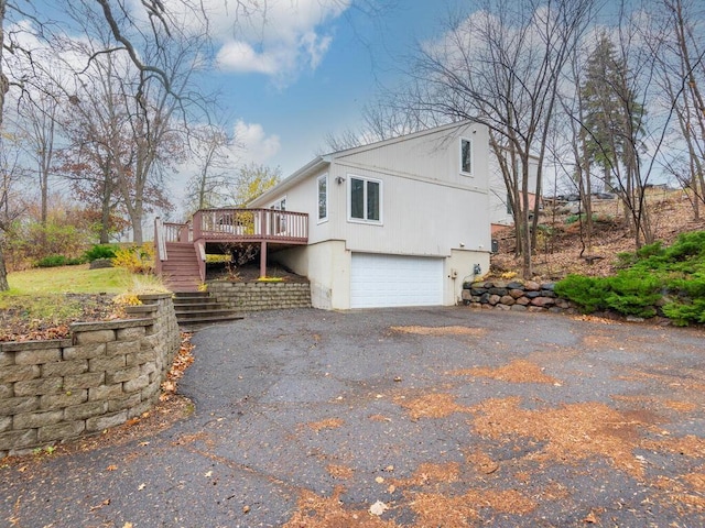 view of side of property featuring a garage and a deck