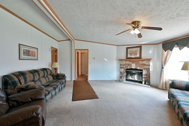 living room featuring ornamental molding, a textured ceiling, light colored carpet, ceiling fan, and a stone fireplace