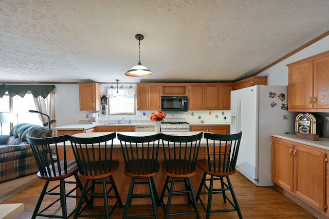 kitchen featuring a textured ceiling, light hardwood / wood-style flooring, white appliances, and ornamental molding