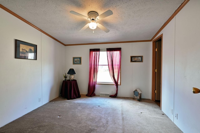 spare room featuring a textured ceiling, light colored carpet, ceiling fan, and ornamental molding