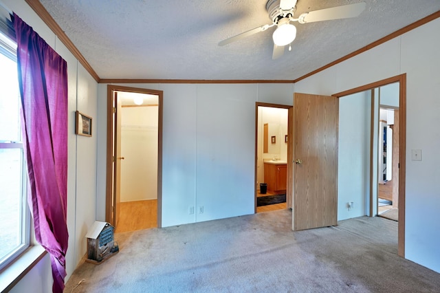 unfurnished bedroom with carpet, a textured ceiling, ceiling fan, crown molding, and lofted ceiling