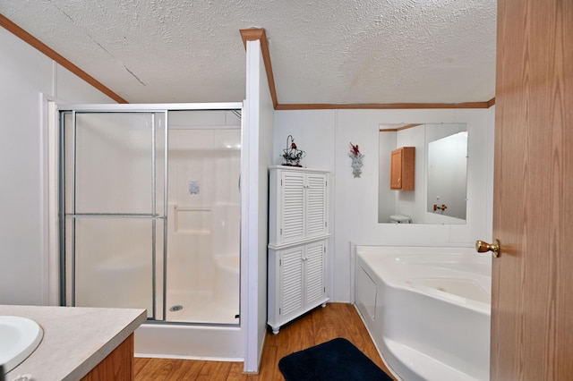 bathroom featuring vanity, a textured ceiling, hardwood / wood-style flooring, and independent shower and bath