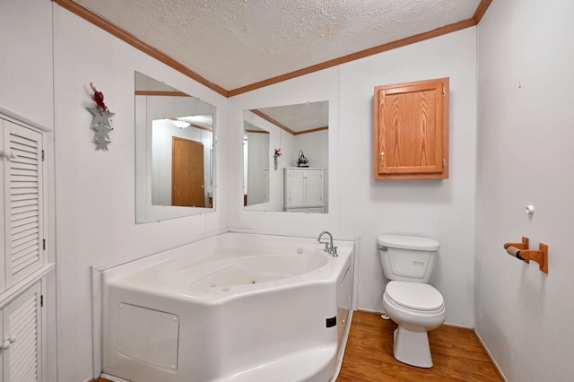 bathroom featuring a tub to relax in, wood-type flooring, a textured ceiling, and ornamental molding