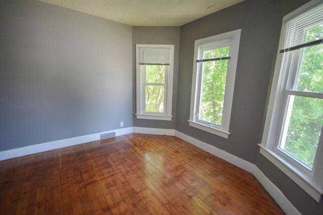 spare room featuring hardwood / wood-style floors and a textured ceiling