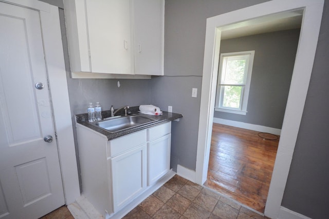 107 3rd Ave SW, Austin, MN 55912 - kitchen with white cabinetry, sink, and light wood-type flooring
