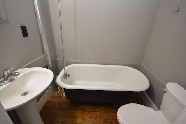 107 3rd Ave SW, Austin, MN 55912 - bathroom featuring hardwood / wood-style floors, a tub to relax in, and toilet