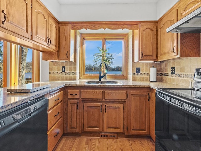 kitchen with a wealth of natural light, sink, black appliances, and extractor fan