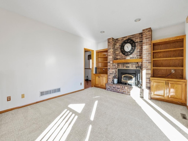 unfurnished living room featuring light colored carpet and a wood stove