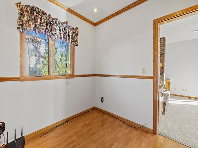 empty room with wood-type flooring and crown molding