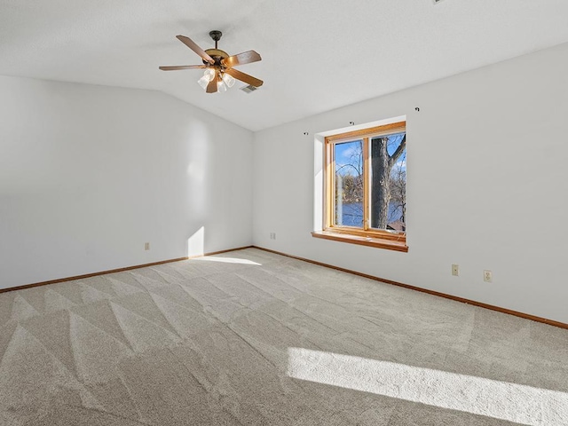 carpeted spare room featuring ceiling fan and lofted ceiling