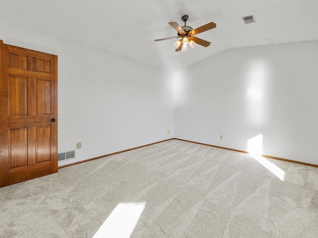 carpeted spare room with ceiling fan and vaulted ceiling