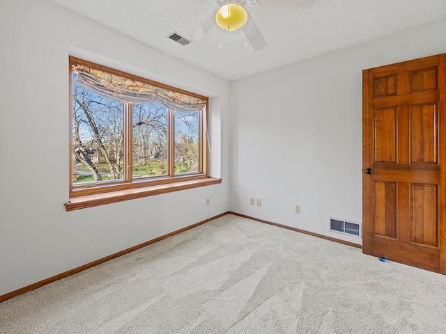 carpeted spare room with ceiling fan