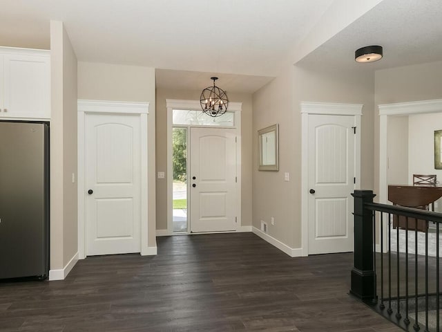 foyer featuring dark hardwood / wood-style flooring and an inviting chandelier