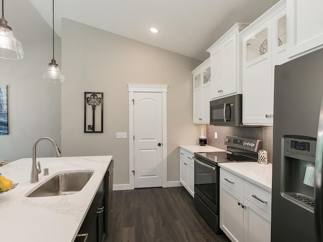 kitchen featuring vaulted ceiling, sink, black appliances, pendant lighting, and white cabinets