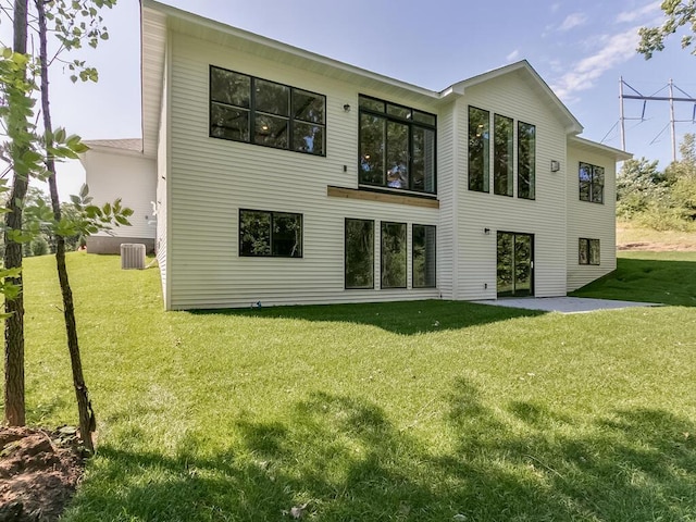 back of property with cooling unit, a yard, and a patio