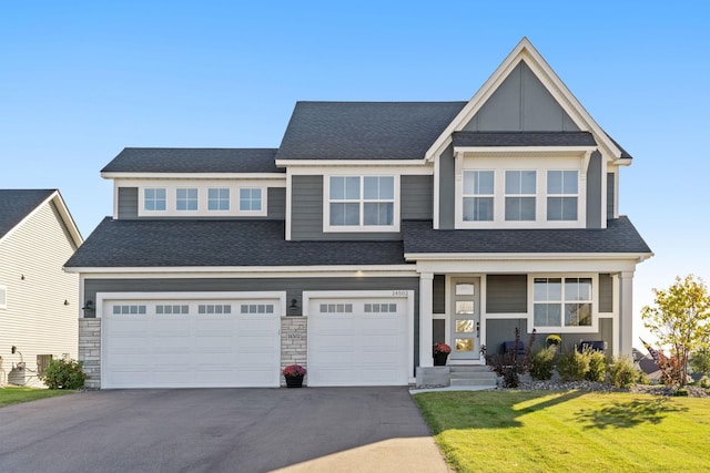 craftsman house featuring a front yard and a garage