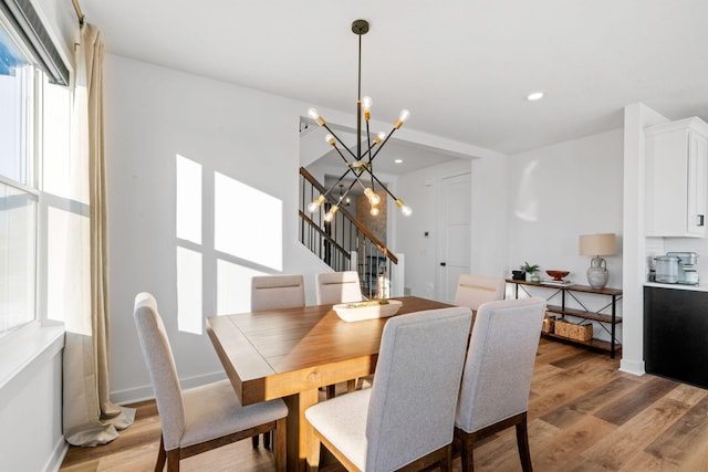 dining space featuring an inviting chandelier and light hardwood / wood-style flooring