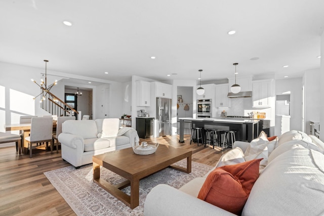 living room featuring light hardwood / wood-style flooring and a notable chandelier