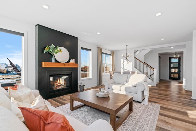 living room featuring a fireplace, hardwood / wood-style floors, and a chandelier