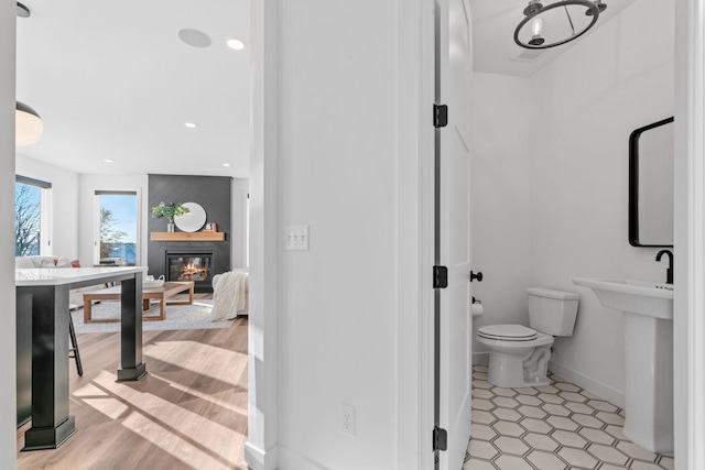 bathroom featuring a fireplace and toilet