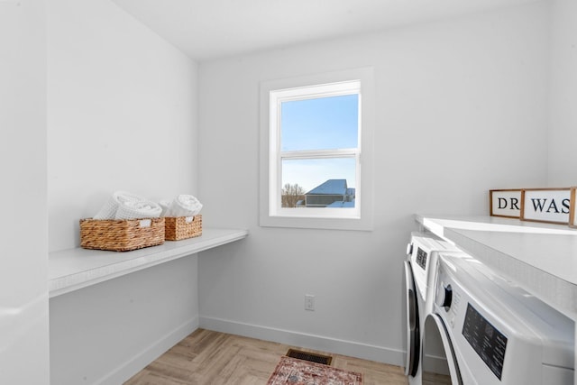 laundry area with independent washer and dryer and light parquet flooring