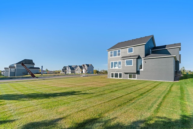 rear view of house featuring a lawn