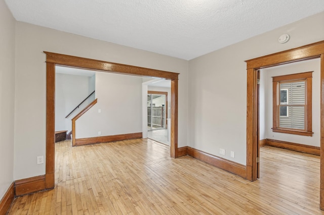 empty room featuring a textured ceiling and light wood-type flooring