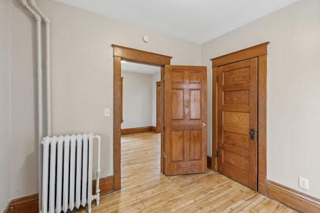 hallway with light wood-type flooring and radiator