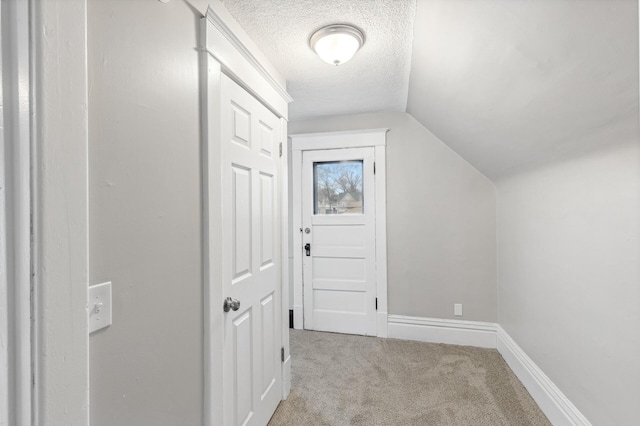 bonus room with a textured ceiling, light colored carpet, and vaulted ceiling