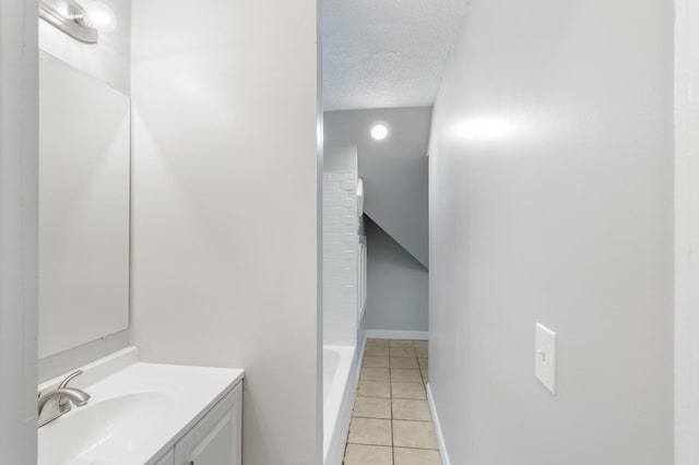 bathroom with tile patterned floors, vanity, and a textured ceiling