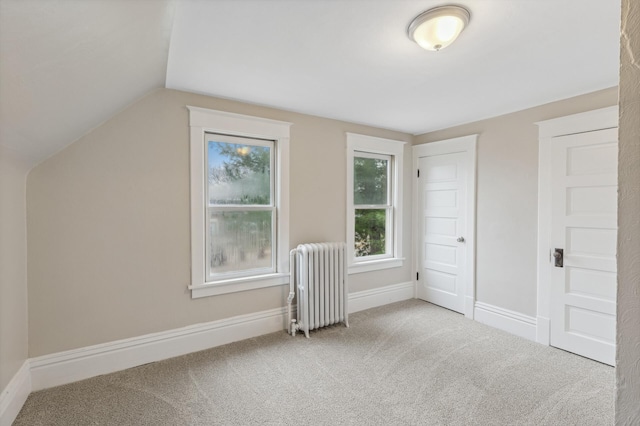 bonus room featuring radiator heating unit, carpet floors, and vaulted ceiling