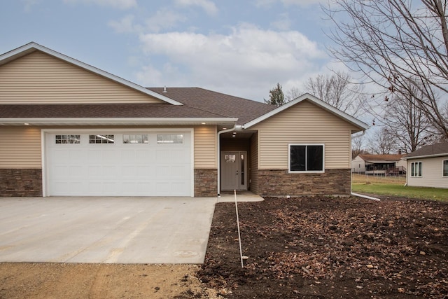 view of front facade featuring stone siding, roof with shingles, driveway, and an attached garage