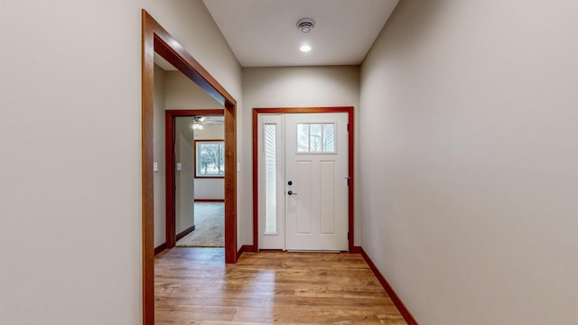 foyer entrance with light wood-style floors and baseboards