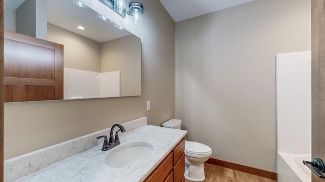 bathroom with a shower, toilet, wood finished floors, a washtub, and vanity