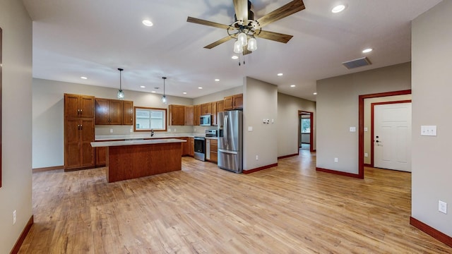 kitchen with appliances with stainless steel finishes, light wood-type flooring, light countertops, and recessed lighting