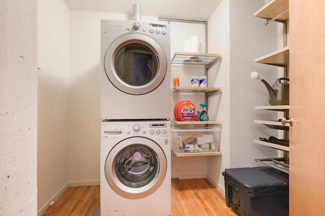 laundry area featuring stacked washer and dryer and light hardwood / wood-style floors