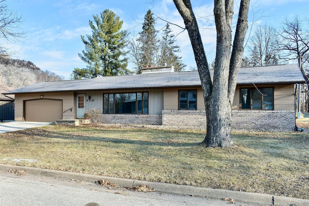 single story home featuring a front yard and a garage