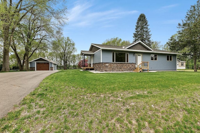 single story home featuring a garage, an outbuilding, and a front lawn