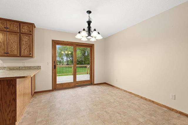 unfurnished dining area featuring a notable chandelier