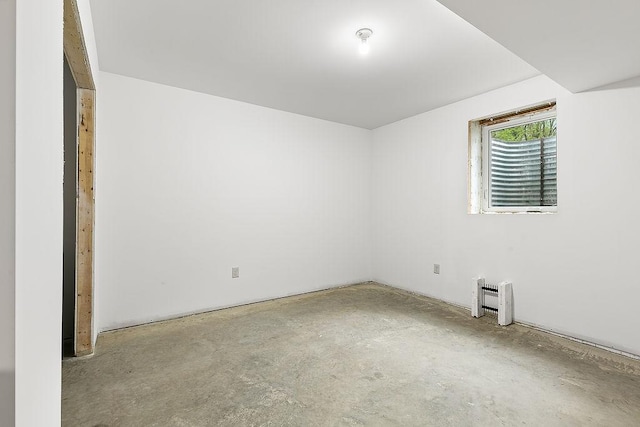 spare room with unfinished concrete flooring and heating unit