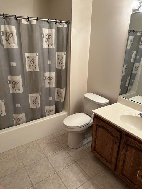 full bathroom featuring tile patterned floors, vanity, shower / bath combination with curtain, and toilet