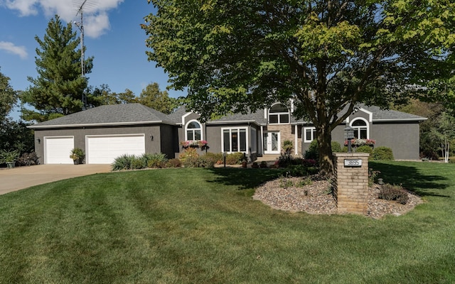 view of front of home with a garage, a front lawn, concrete driveway, and stucco siding