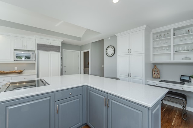 kitchen featuring built in appliances, light countertops, dark wood-style floors, and white cabinets